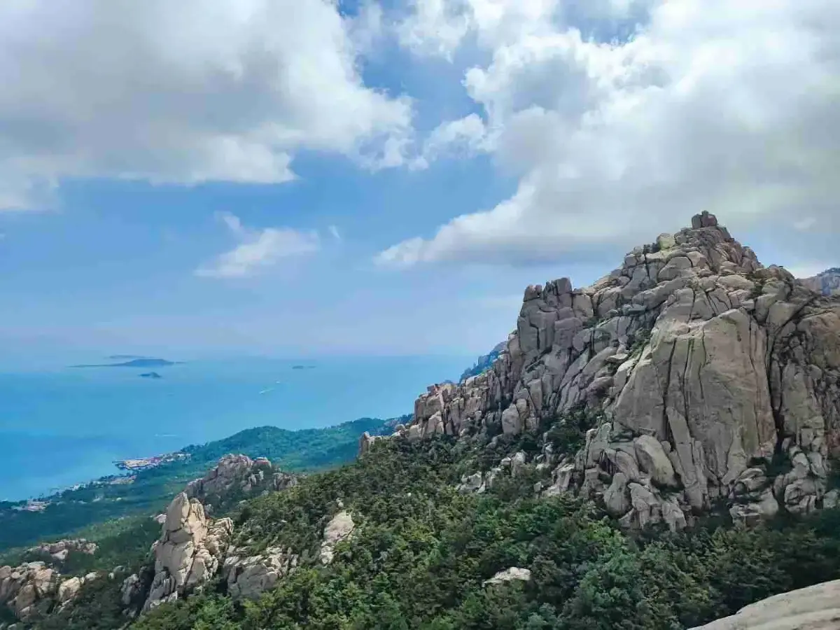 Granite peaks of Laoshan rising over the sea with clouds