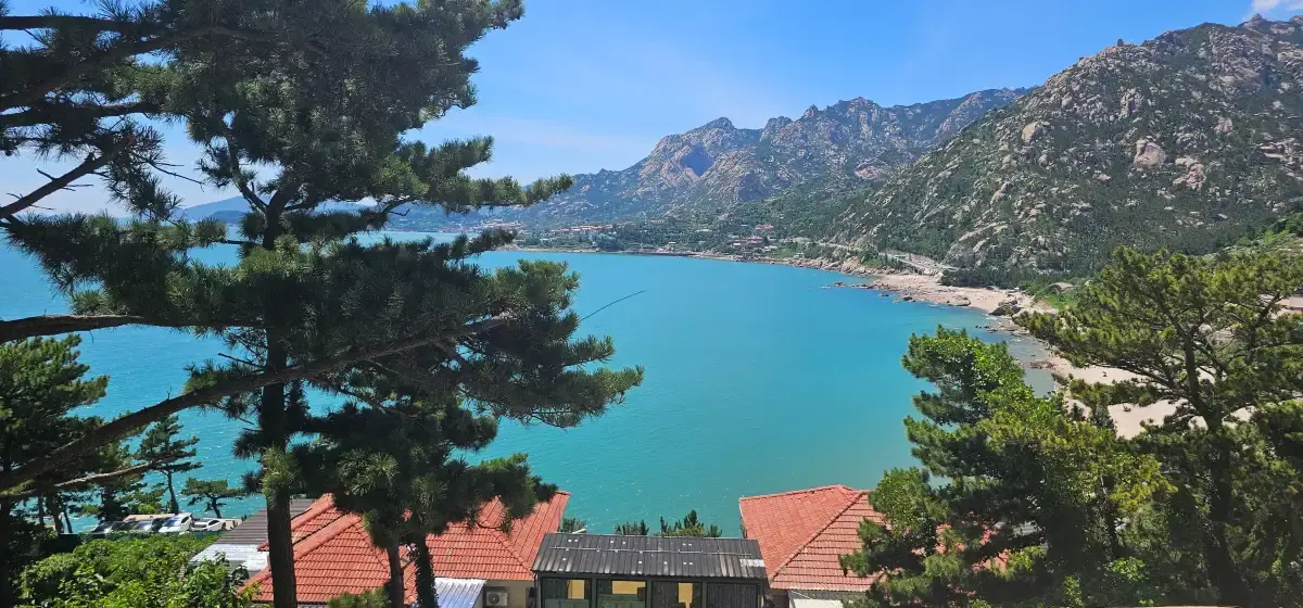 Turquoise bay between ridges with red roofs below