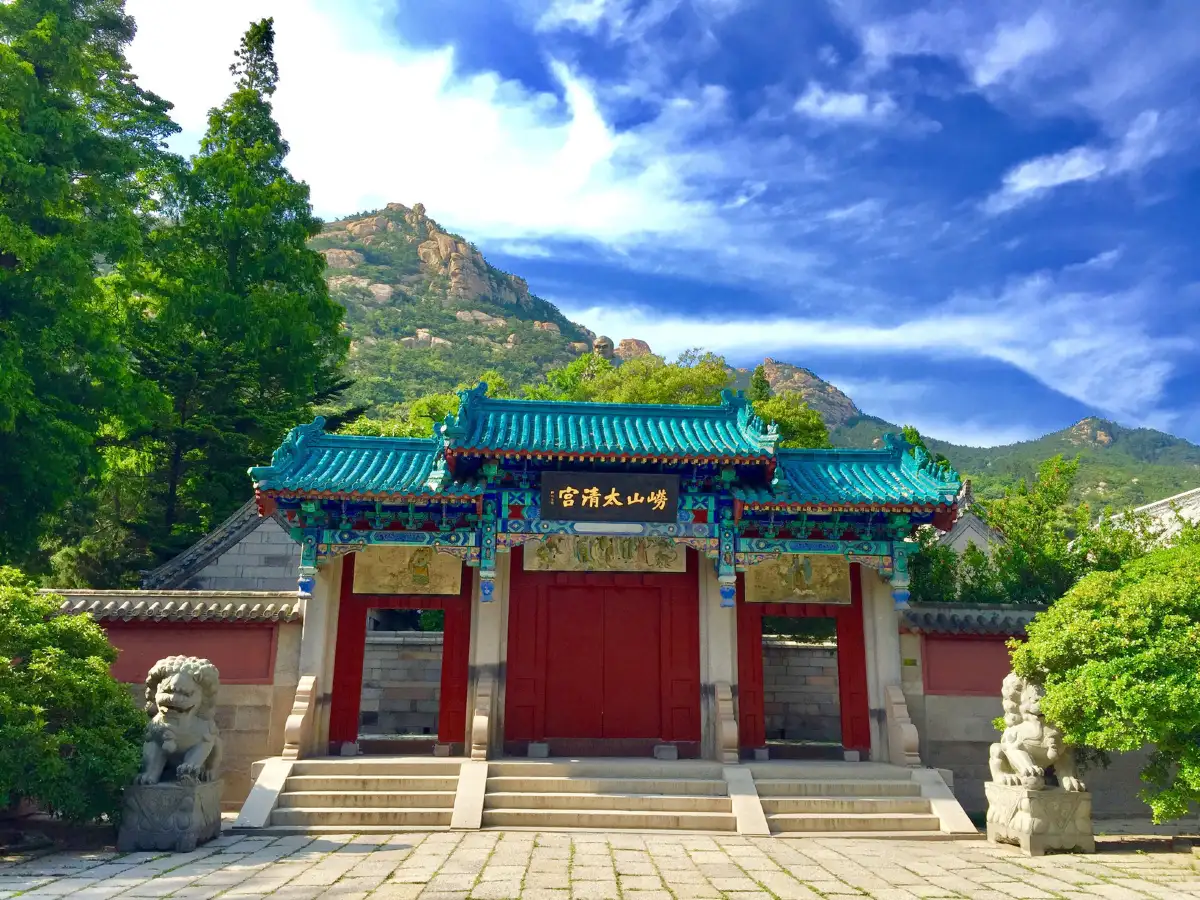 Teal-roofed gate of Taiqing Palace framed by green hills